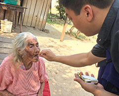 Father Viet Hoang visits a sick woman in Paragraph and provides the Eucharist