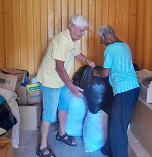 An SVD brother unloads relief cargo in Jamaica, demonstrating the physical commitment of a feet-on-the-ground missionary providing real-world outreach.