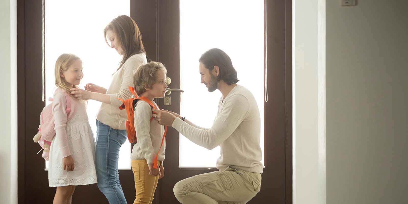 Mother and father getting children ready for school