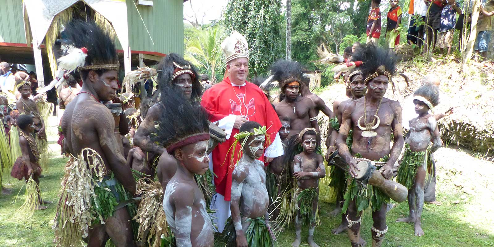 Bishop Joe Roszynski standing with Natives in Papua New Guinea