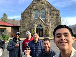 Volunteers with Father Thien in front of a Parish church.