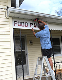 Hanging a new sign for the Gassaway Food Pantry.