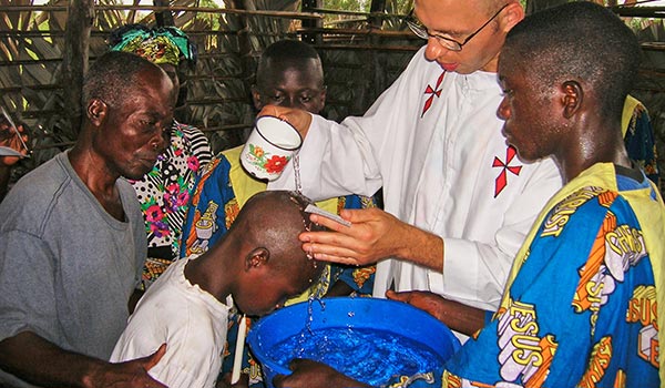 Padre Tomas baptizando criança em Congo