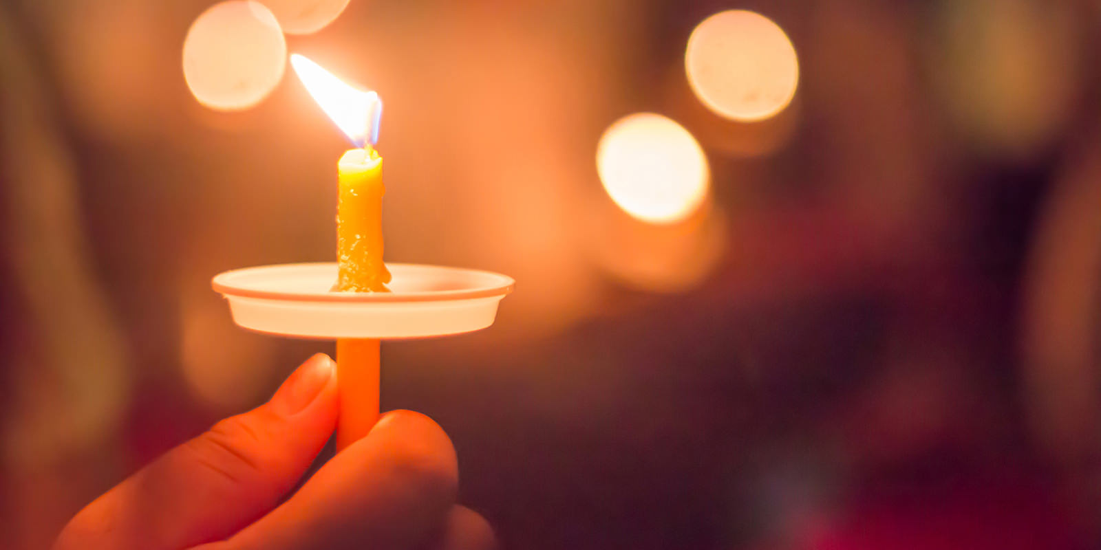 Hand holding memorial candle