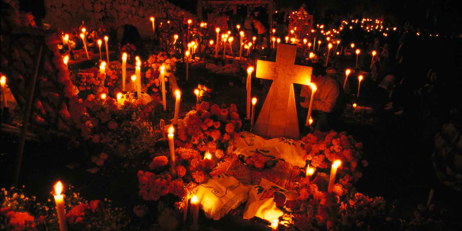 Candles throughout a cemetary during Día de los Muertos in Mexico.
