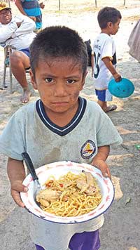 A hungry child in Bahia Negra, Paraguay receives received a donated meal