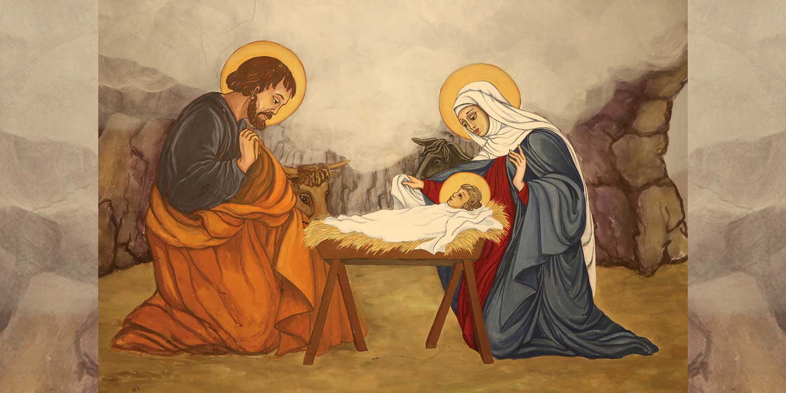 A painting of baby Jesus in the manager with Mary and Joseph on each side.