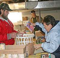 A volunteer helping a local resident with food pantry items to take home.