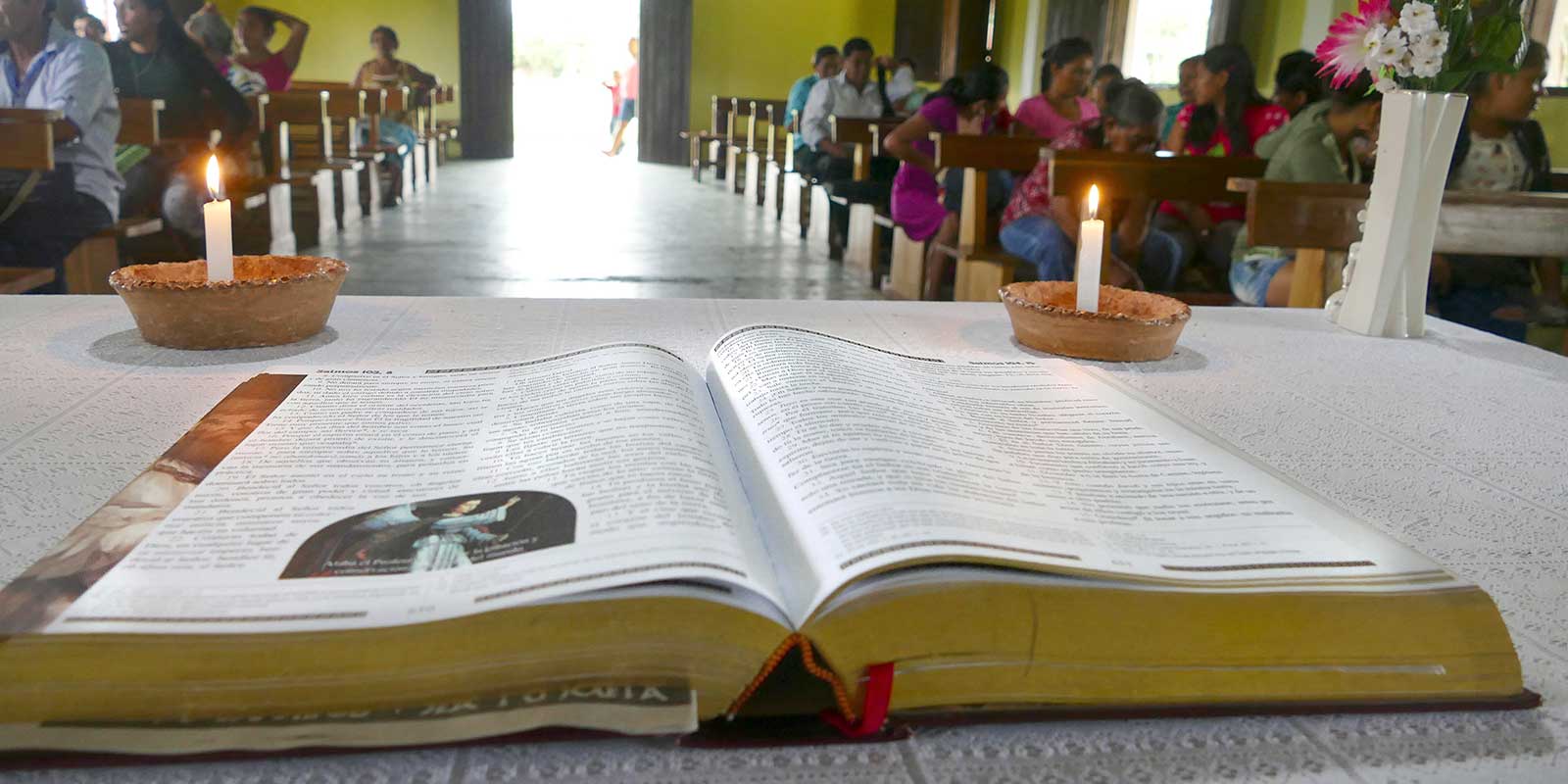 Bible sitting on altar facing a room of congregants