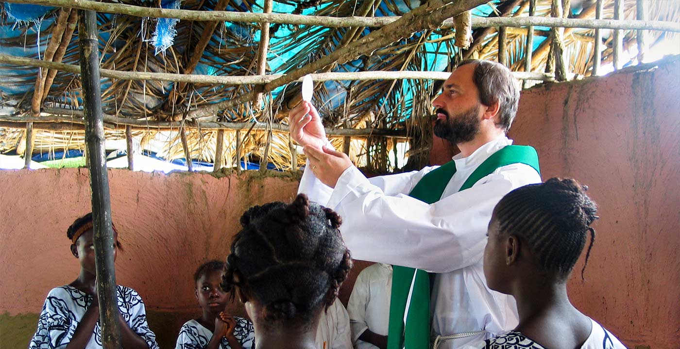 O padre Jacek Gniadek levanta a hóstia durante a Santa Missa na Tanzânia.