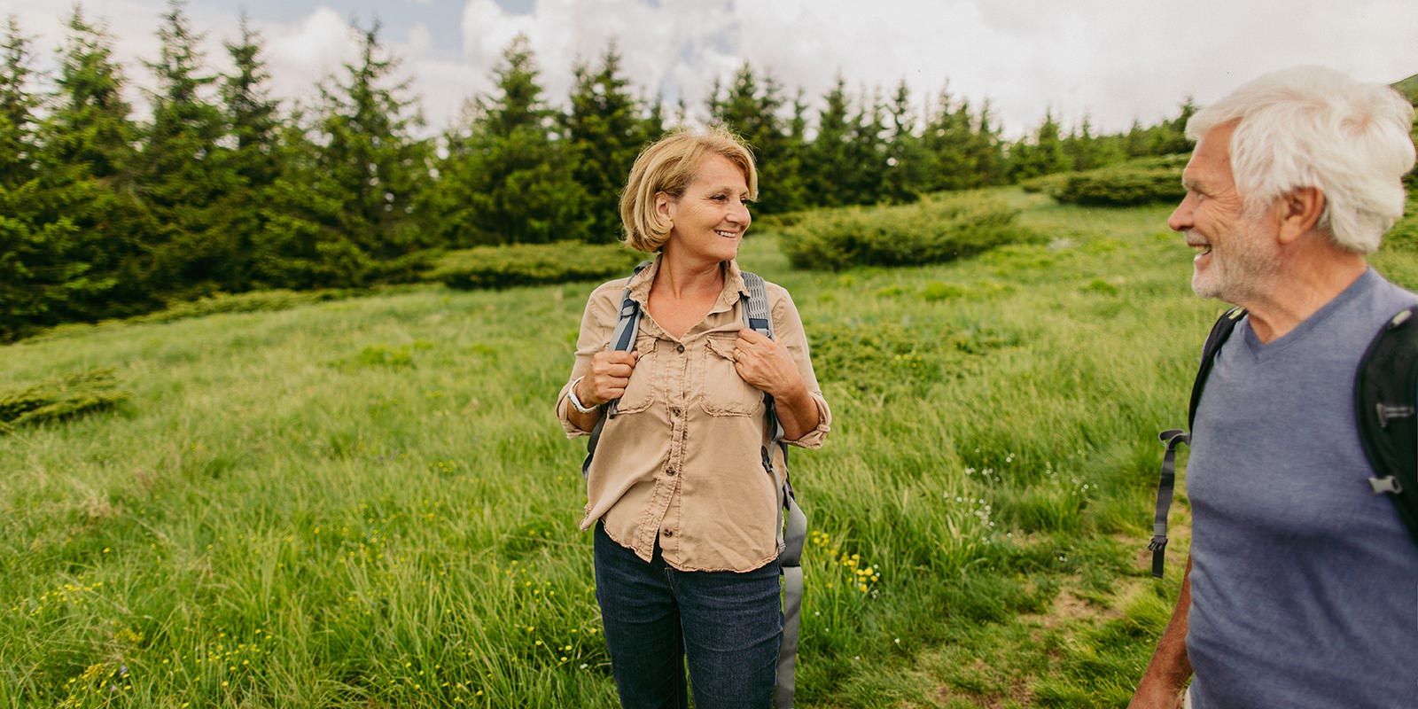 A couple enjoying retirement hiking on a trail through some hills