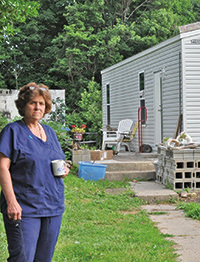 Local resident, Kay, stands in front of her FEMA trailer after he home had burned down.