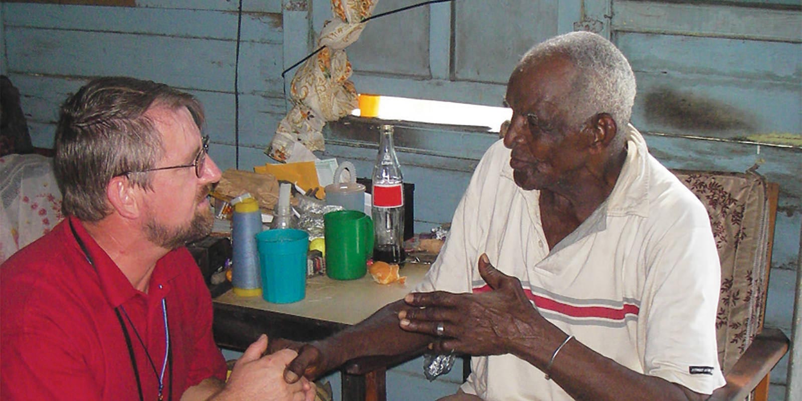 El padre Bernard Latus en Jamaica escucha las preocupaciones de un residente local.