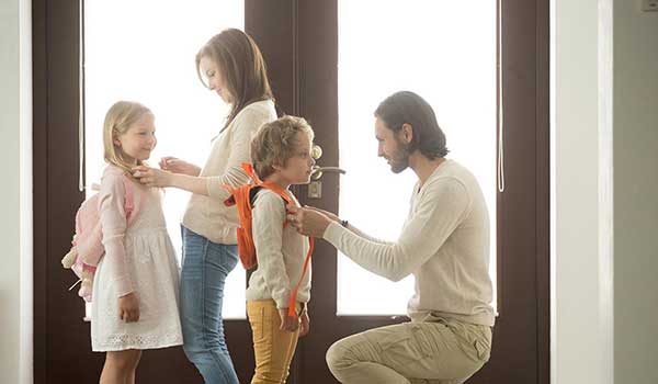 Mother and father getting their children ready for school