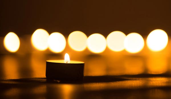 A row of softly lit tea light memorial candles