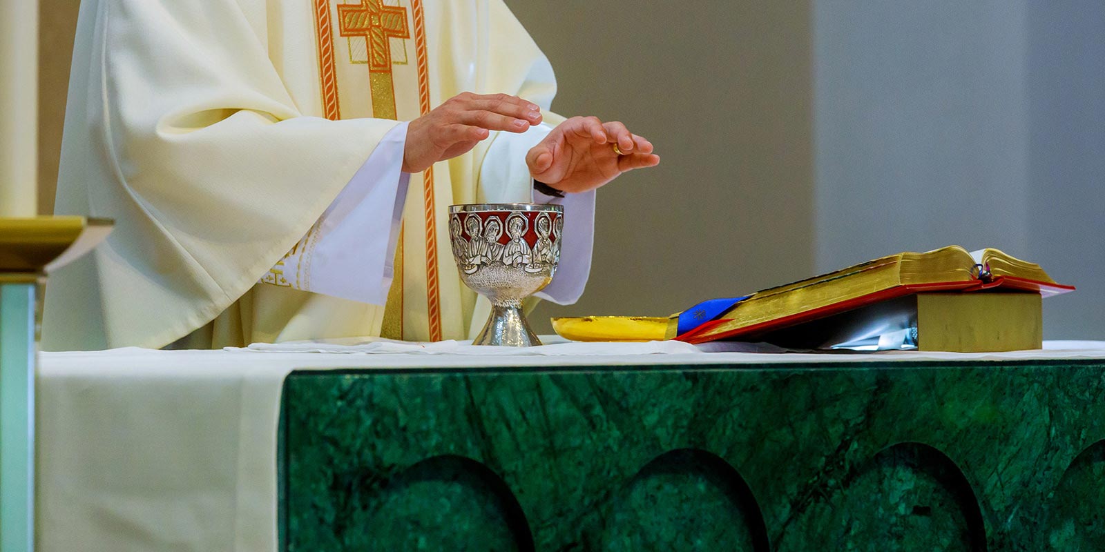 Eucaristía, el sacerdote bendice el pan y el vino en el altar.